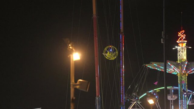 This video shows a fair gyroscope slingshot ride at night.