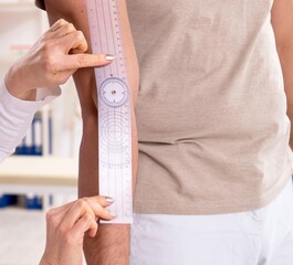Female doctor checking patient's joint flexibility with goniomet