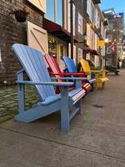 Fototapeta na wymiar Row of colorful outdoor chairs along a sidewalk