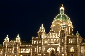 Illuminated BC Parliament Building at night in Victoria Inner Harbor in Canada