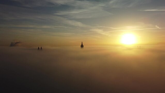 Aerial footage of St. Christopher Cathedral bell tower and Natalini-Toren covered with dense fog
