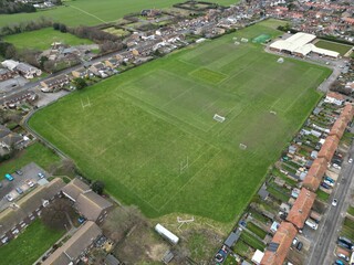 Aerial shot of a football field surrounded by buildings in a suburban area