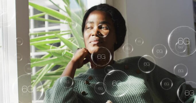 Animation of 6g text over african american woman at home - Powered by Adobe