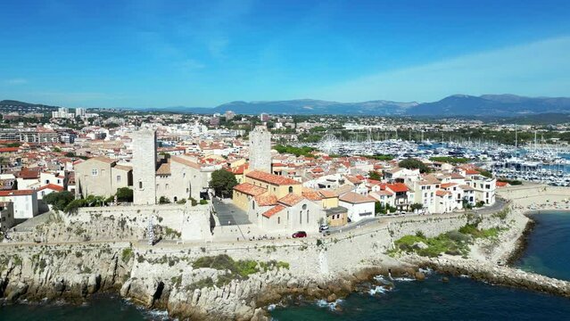 Drone footage of Antibes town with Chateau Grimaldi castle along sea in France on a sunny day