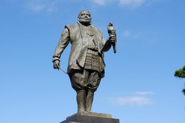 Obraz premium Bronze statue of a man with a bird in his hand against a clear sky in the background