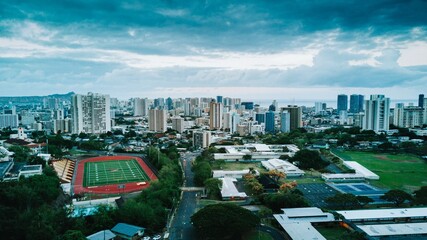 Fototapeta na wymiar Aerial view of a cityscape with a sport field on a cloudy day