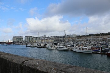 Scenic view of boats moored at a harbor on a cloudy day