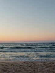 Obraz premium Beach scene featuring a beautiful sunset with rolling waves in the foreground