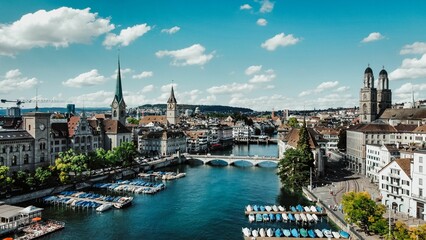 Scenic view of a riverbank with multiple sailboats and motorboats in the waters in Zurich