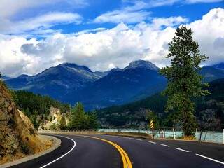 Two-lane highway winding through a majestic mountain landscape in Whistler, British Columbia