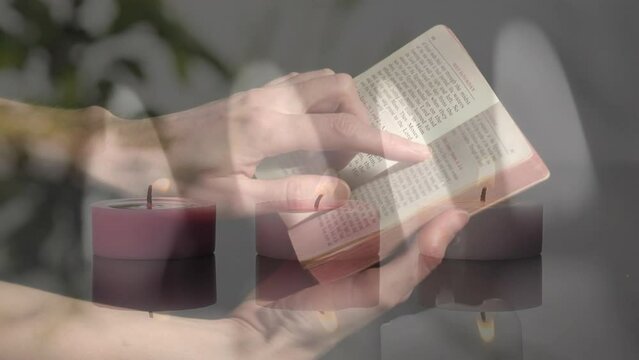 Composite video of burning candles against close up of woman reading a bible and praying