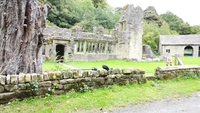 Drone footage of the wycoller Hall with grass in front and trees in the background, Lancashire