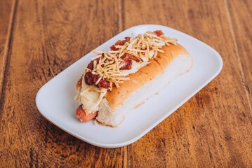 Delicious and juicy hot dog served on a soft and lightly toasted bun on a wooden table.