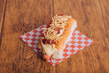 Delicious and juicy hot dog served on a soft and lightly toasted bun on a wooden table.