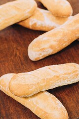 Freshly-baked bread resting on a wooden table top, with a light dusting of flour