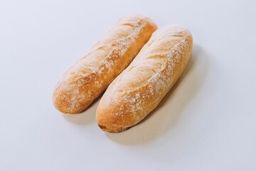 Freshly-baked bread resting on a white table top, with a light dusting of flour