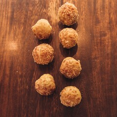 seven cookies on a wooden table are arranged in a triangle