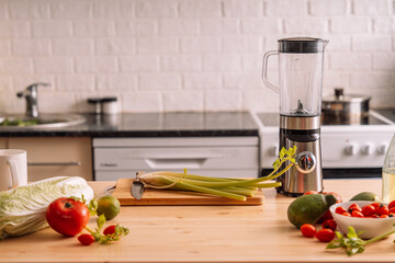 Fresh vegetables with a blender on a wooden table in front of the kitchen.