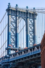 Vertical shot of the Manhattan Bridge between buildings in the Dumbo neighborhood in Brooklyn, NYC