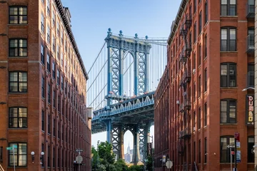 Fotobehang Manhattan Bridge between buildings in the Dumbo neighborhood in Brooklyn, NYC © Wirestock