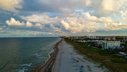 Fototapeta premium Aerial view of buildings on the beach against sea waves on a sunny day