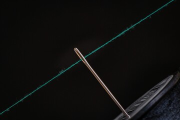 Closeup of a Needle and the thread on the black background