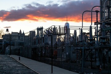 Electric power station in the foreground, with Manhattan Bridge at sunset.