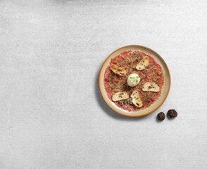 Top view of a dish of carpaccio salad with bread on a table