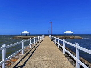 Obraz premium Two gazebos on a pier near a tranquil body of water.