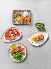 Top view of a various delicious dishes on a gray background