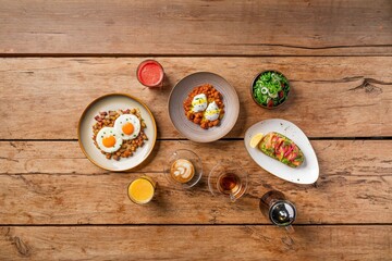 Top view of various delicious dishes served on a wooden table