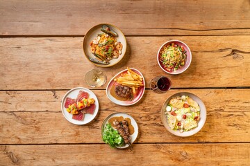 Top view of various delicious dishes served on a wooden table