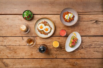 Top view of various delicious dishes served on a wooden table