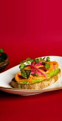 Closeup of salmon and avocado on a toast on a red background