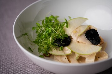 Closeup of a bowl of apple slices with black truffle