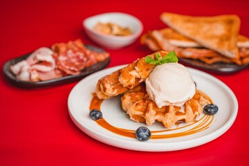 Closeup of waffles with ice cream on a red background