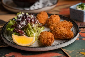 Closeup of chicken nuggets with lettuce and lemon on a plate