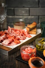 Vertical of a plate of freshly sliced meat on a wooden board