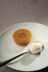 Closeup of a pudding served with a spoon of yogurt