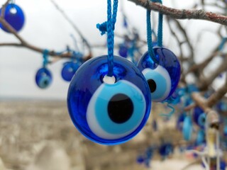 Closeup of tree with multiple blue evil eye charms hanging from it
