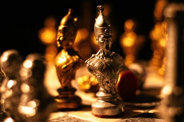 Small chess board with intricately crafted golden chess pieces arranged on top of it