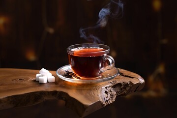 Cup of hot tea and small sugar pieces sitting on a wooden table