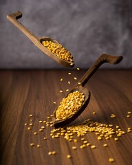 Wooden spoons filled with a variety of cotyledons and beans, including peas - obrazy, fototapety, plakaty