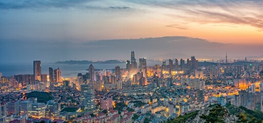 Night skyline of Qingdao, Shandong province, in China, illuminated by a gorgeous sunset.