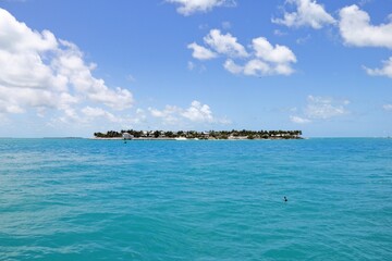 Scenic view of the ocean, with a blue sky and island in the background. Miami, Florida, USA.
