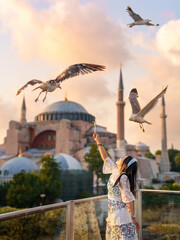 Lifestyle, Asian woman tourist feeding seagulls at view point in vacation. There is a Hagia Sophia...