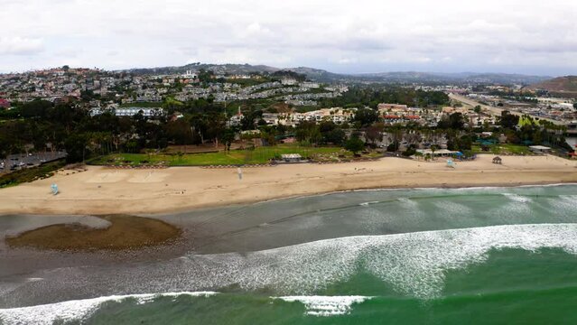 Drone shot of Doheny State Beach with the cityscape of Dana Point in the background, USA