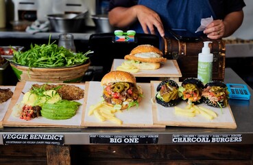 Person preparing burgers on some wooden cutting boards by herself