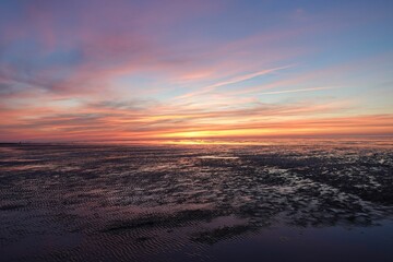 Stunning sunrise on the beach with a few wispy clouds in the sky.