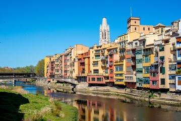 View of a city in Girona, Catalonia, Spain, with the tranquil surface of a nearby river